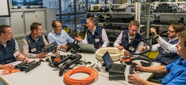 igus Mitarbeiter sitzen mit Produkten am Tisch