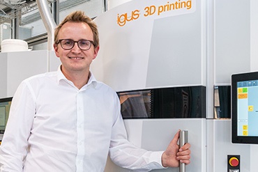 Tom Krause steht vor SLS 3D-Drucker